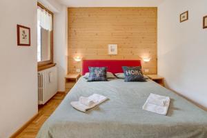 a bedroom with a large bed with two towels on it at Chalet Holly in Bormio