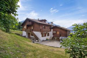 a large wooden house on a hill with a yard at Chalet Holly in Bormio