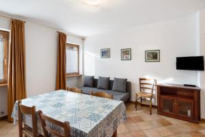 a living room with a table and a couch at Residence Malibu Appartamento 8 in Falcade