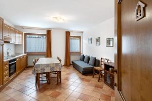 a kitchen and living room with a table and a couch at Residence Malibu Appartamento 8 in Falcade