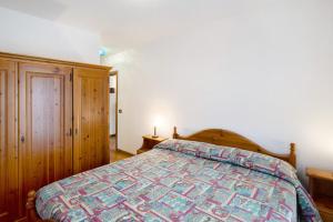 a bedroom with a bed with a colorful bedspread at Residence Malibu Appartamento 8 in Falcade