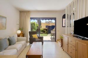 a living room with a couch and a tv at Free Airport Shuttle and Parking in San Bartolomé