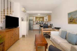 a living room with a couch and a tv at Free Airport Shuttle and Parking in San Bartolomé