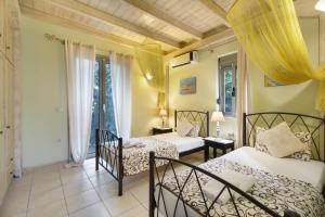 a bedroom with two beds and two chairs at Villa Fotini Lefkada in Lefkada +25 photos