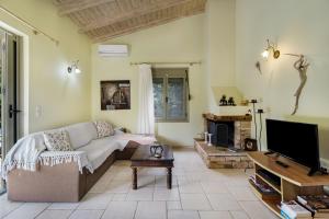 a living room with a couch and a flat screen tv at Villa Fotini Lefkada in Lefkada