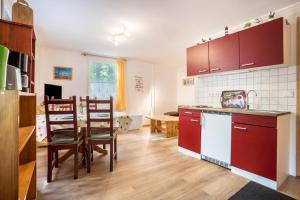 a kitchen with red cabinets and a dining room at Bungalow Arkona Bgl 1 in Dranske
