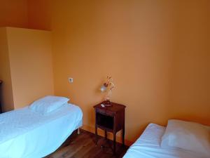 a bedroom with two beds and a table with a lamp at La Maison De Carmensac in Meyrals