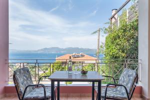 a table and chairs on a balcony with a view of the ocean at Christianna studios in Nikiana
