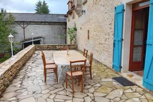 a patio with a table and chairs on a stone patio at La Maison De Carmensac in Meyrals
