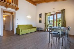 a living room with a table and a green couch at Agriturismo Bocca Nevese Pino in Tremosine Sul Garda
