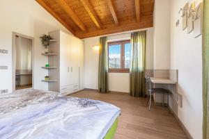 a bedroom with a bed and a desk and a window at Agriturismo Bocca Nevese Pino in Tremosine Sul Garda