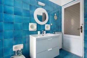 a blue tiled bathroom with a sink and a mirror at Levanto A 50 Metri dal Mare in Levanto +30 photos