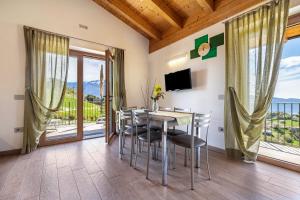 a dining room with a table and chairs and a balcony at Agriturismo Bocca Nevese Pino in Tremosine Sul Garda