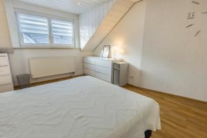 a bedroom with a white bed and a window at am Salinensee in Bad Dürrheim