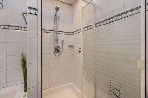 a white bathroom with a shower and a tub at am Salinensee in Bad Dürrheim +15 photos