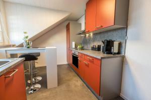 a kitchen with orange cabinets and a staircase at am Salinensee in Bad Dürrheim