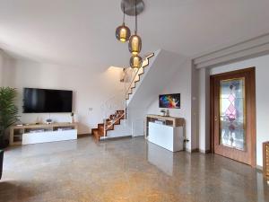 a living room with a television and a staircase at Royal Residence Abano Terme in Abano Terme