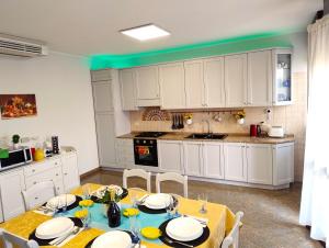 a kitchen with white cabinets and a table with chairs at Royal Residence Abano Terme in Abano Terme