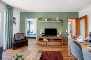 a living room with a television and a table at Ut Huuske in Dorsel