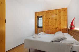 a bedroom with a bed with a wooden wall at Maison Le Cré Appartamento 3 in Introd