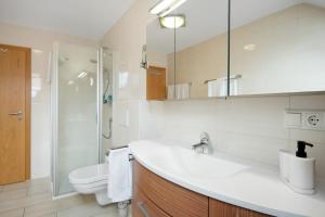 a white bathroom with a sink and a toilet at Appartement Rosi in Ihrlerstein +22 photos