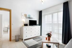 a living room with a television and a white dresser at Appartement Rosi in Ihrlerstein