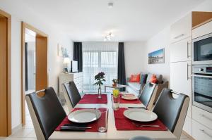 a dining room with a table and chairs and a kitchen at Appartement Rosi in Ihrlerstein