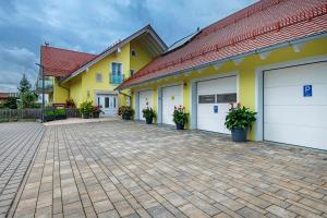 a row of white garage doors on a yellow building at Appartement Rosi in Ihrlerstein