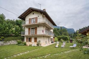 a house with a balcony and a yard at Villa Fiore in Lamon
