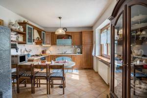 a kitchen with wooden cabinets and a table and chairs at Villa Fiore in Lamon +22 photos