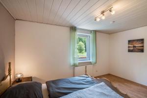a bedroom with a bed and a window at Ferienwohnung Waldblick in Freudenstadt