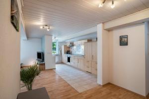 a large kitchen with white walls and wooden cabinets at Ferienwohnung Waldblick in Freudenstadt