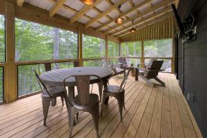 a wooden porch with a table and chairs on a deck at Hemlock Cottage · Hemlock Cottage in Pisgah Forest - Pet Friendl in Brevard