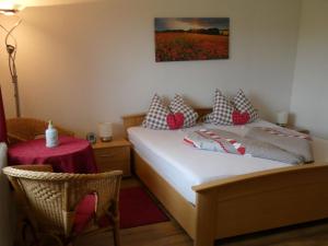 a bedroom with a bed with pillows and a table at Fewo Siglinde Schneider in Freiamt
