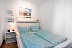a small bedroom with a bed with blue sheets at Ferienwohnung Wölk in Sonthofen