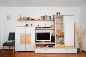 a living room with a tv and a white cabinet at Ferienwohnung Wölk in Sonthofen