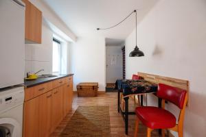 a kitchen with a table with red chairs and a sink at Haus Hauptstrasse 23a in Bühl