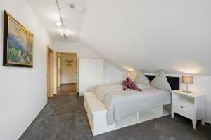 a white bedroom with a white bed and a table at Ferienwohnung Nordschwarzwald in Altensteig