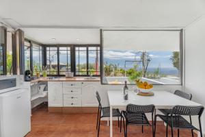 a kitchen with a table and chairs and windows at La Atalaya in Adeje