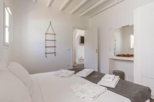 a white room with a bed with towels on it at Ow Andros Suite 5,Private Whirlpool in Andros +21 photos