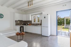 a kitchen with white cabinets and a white refrigerator at Ow Andros Suite 5,Private Whirlpool in Andros