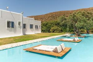 a swimming pool with two chaise lounges on top of it at Ow Andros Suite 5,Private Whirlpool in Andros