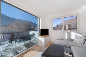a living room with a couch and a large window at Apartment Mountain Suite in Naturno