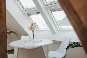 a white dining room with a white table and white chairs at Ferienwohnung Wunderbar in Bad Wildbad