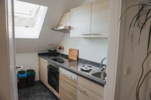a small kitchen with wooden cabinets and a sink at Ferienwohnung Wunderbar in Bad Wildbad +9 photos