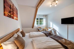 a bedroom with two beds and a flat screen tv at Schätzlehof in Oberwinden