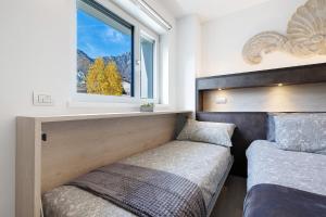 a bedroom with two beds and a window at Eco Del Garda Bnb in Tenno +54 photos