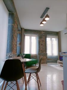 a dining room with a table and green chairs at Valley Apartamentos T1 in Vila Nova de Foz Coa
