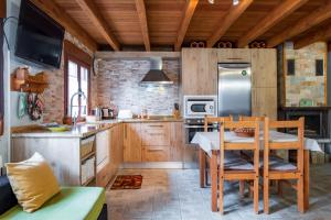a kitchen with wooden cabinets and a table and chairs at Casa La Charca in Amavida