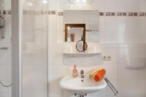 a white bathroom with a sink and a shower at Ferienwohnung Zugspitze in Grainau +13 photos